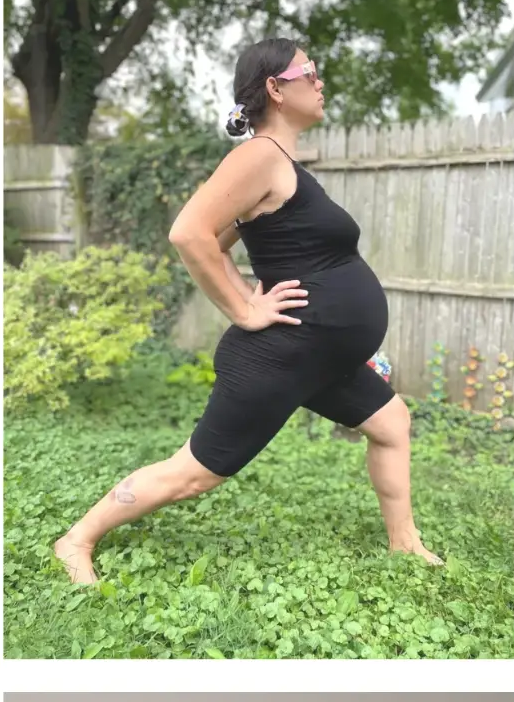 Prenatal standing pose practised outdoors on clover