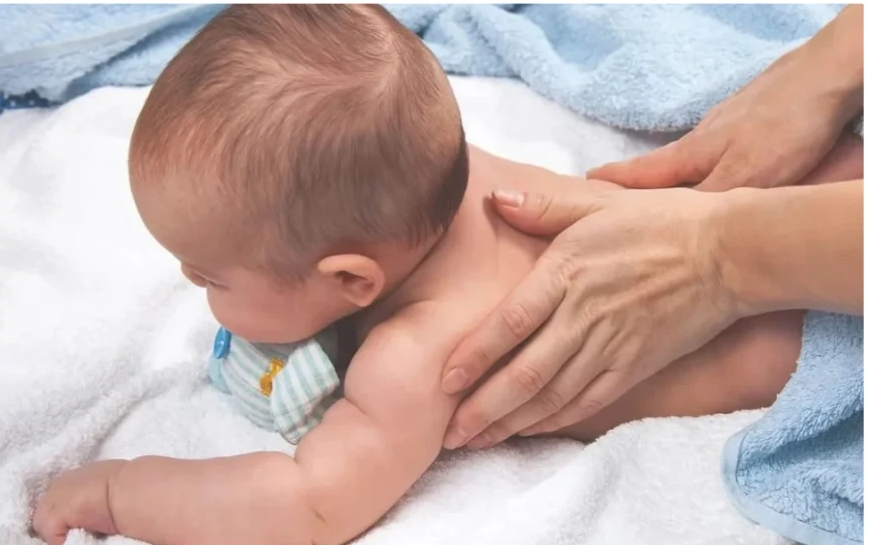 Infant receiving a gentle Shantala massage on a soft towel
