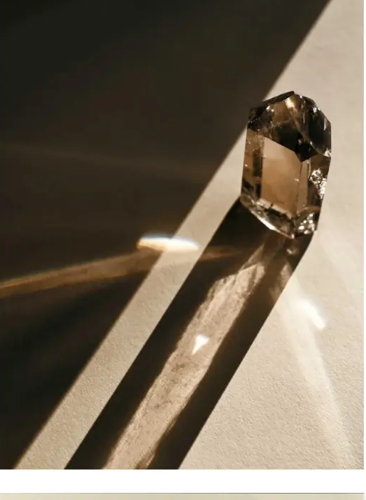 Smoky quartz crystal casting long shadows in sunlight