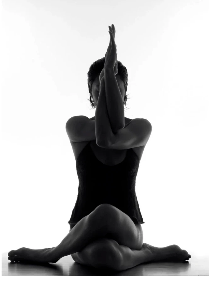 Black and white photograph of a seated eagle arms pose